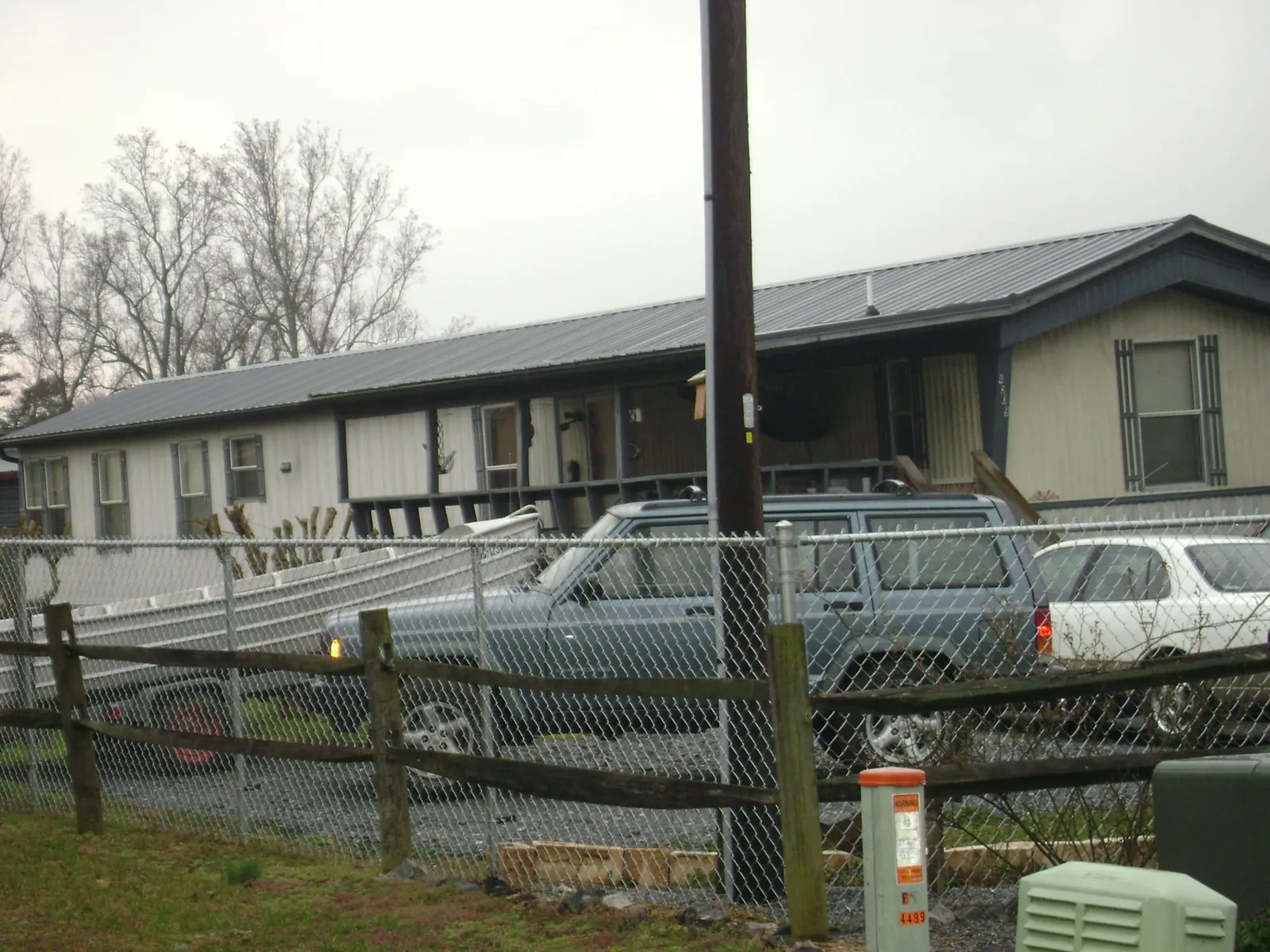 Dark metal roof on a long single story building behind a chain link fence in Hartford